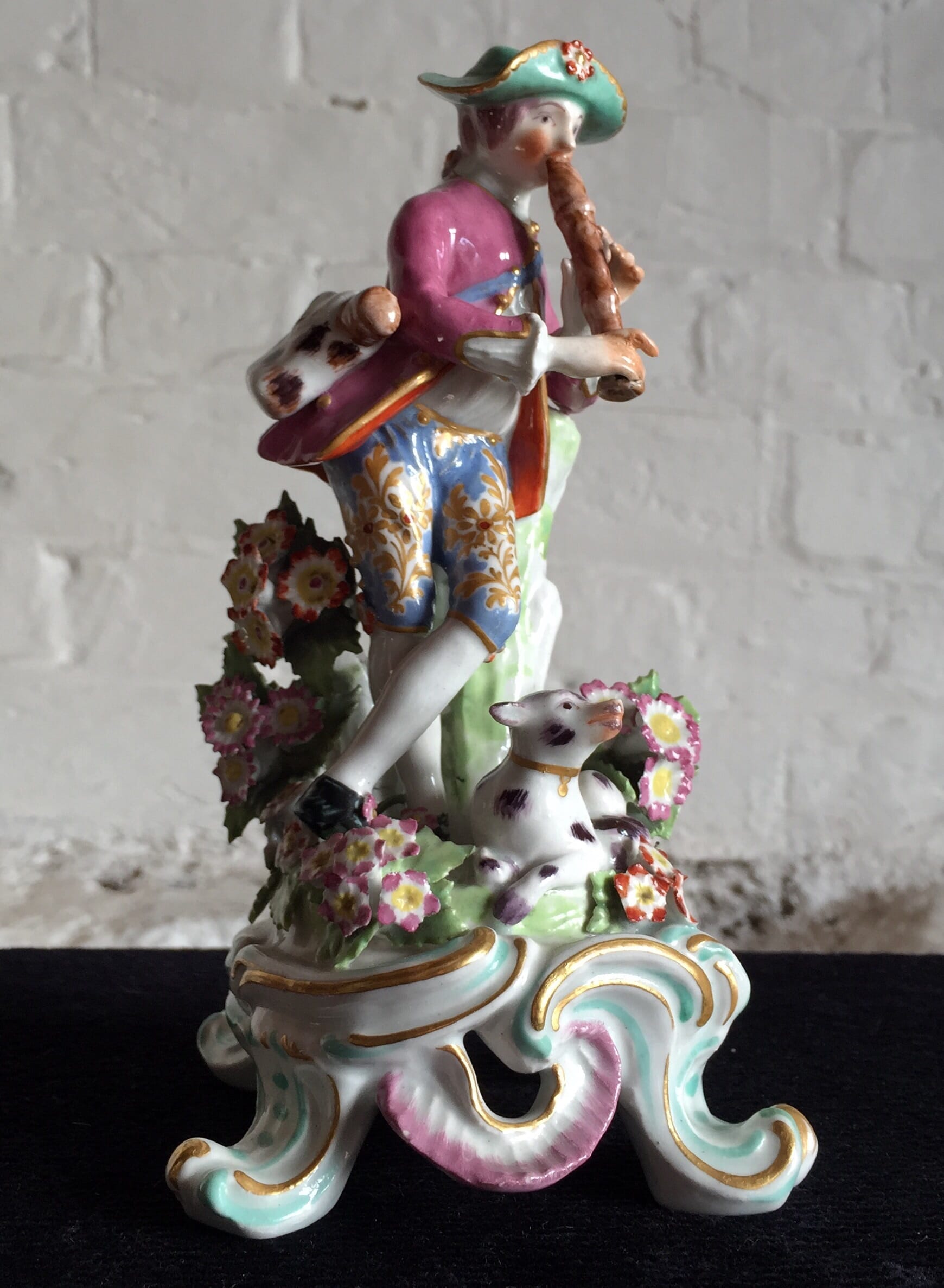 Bow figure of a shepherd playing a flute, a dog at his feet, c.1760-0