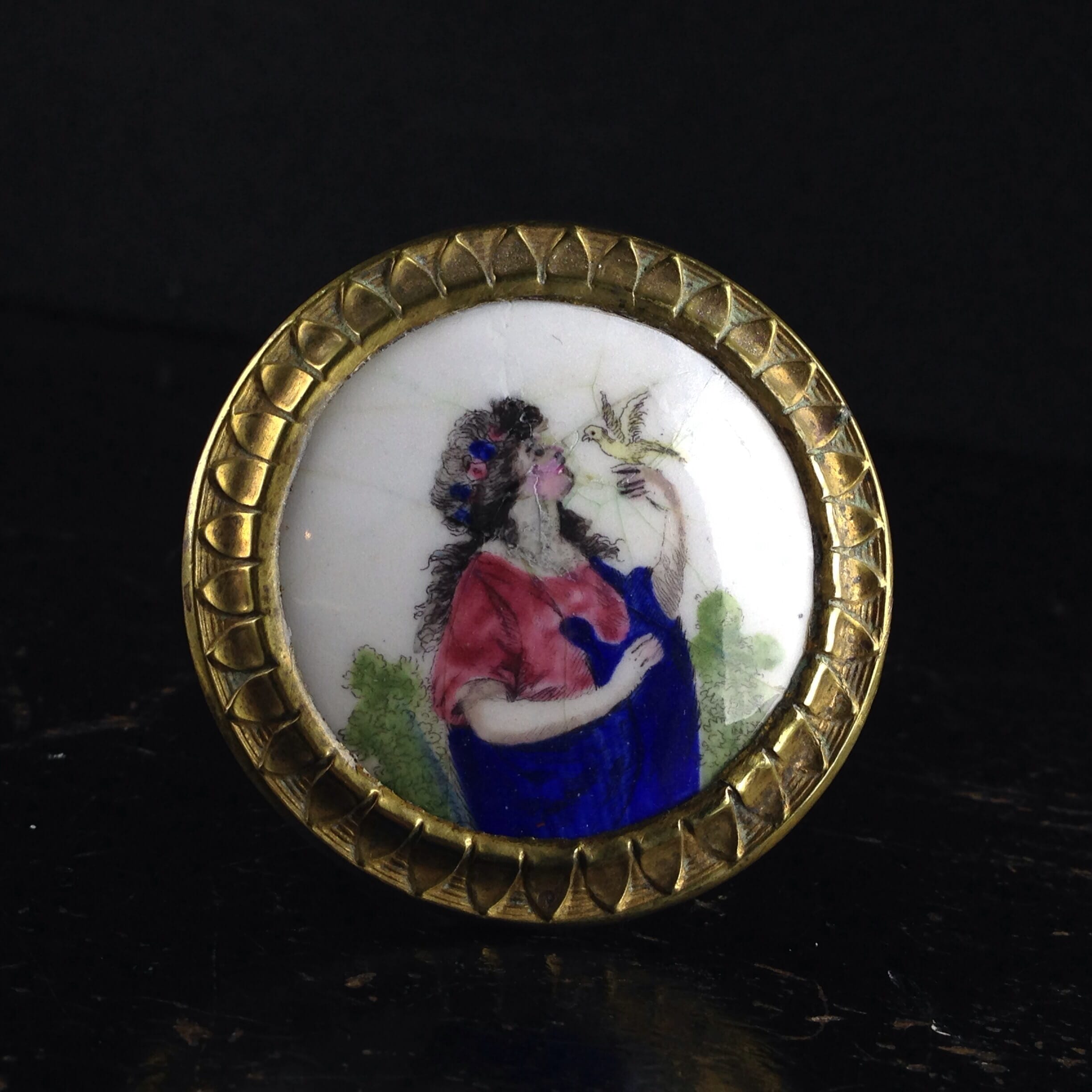 English enamel curtain tie-back, girl with bird, c. 1780. -0