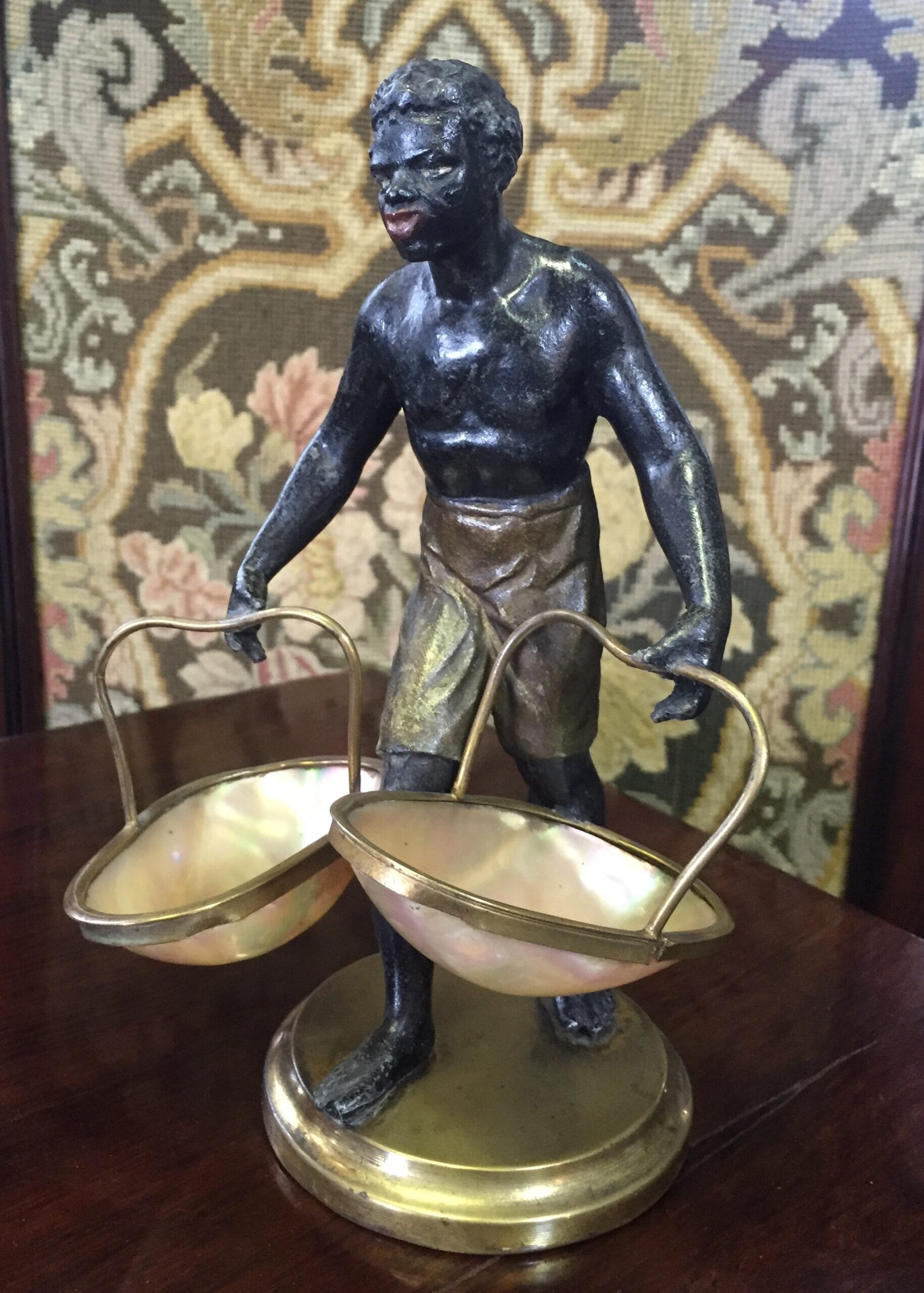 Blackamoor sweetmeat figure of a man holding baskets formed in mother of pearl, c.1870-0