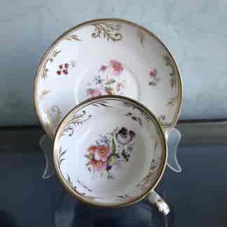 Minton french shape cup and saucer with painted flowers and gilt vine rims, c.1835