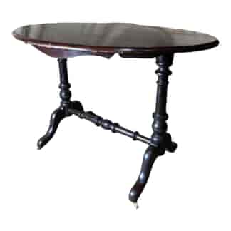 Victorian dark stained kauri pine oval table with porcelain castors, c.1860
