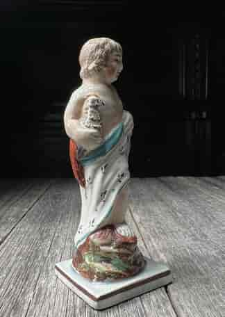  Pearlware figure of a standing boy, holding a large bird, C.1800