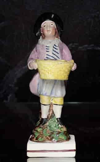 Early Staffordshire figure of a pastry seller, c. 1800