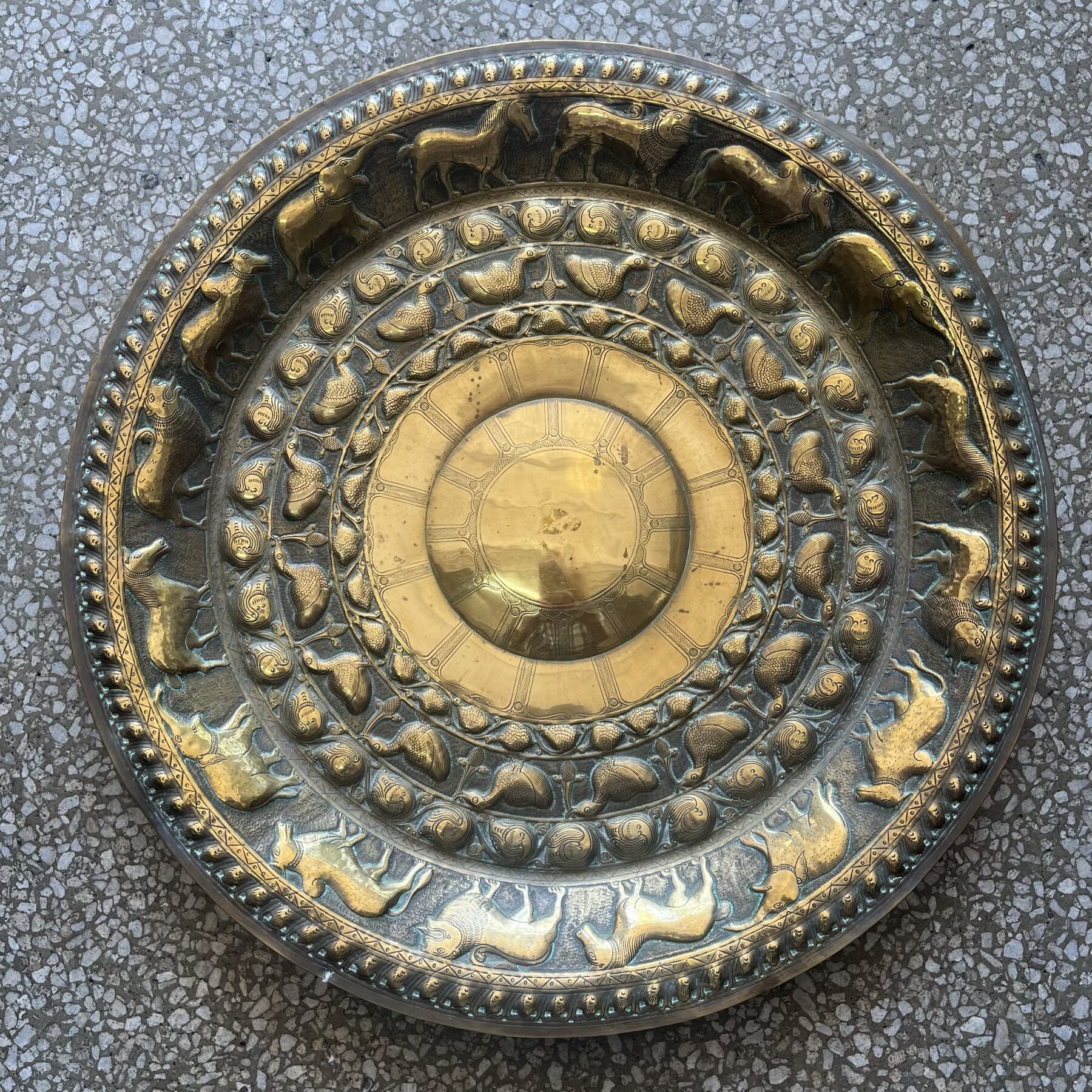 Mughal Indian brass charger with intricately embossed animals and foliate patterns, 19th century