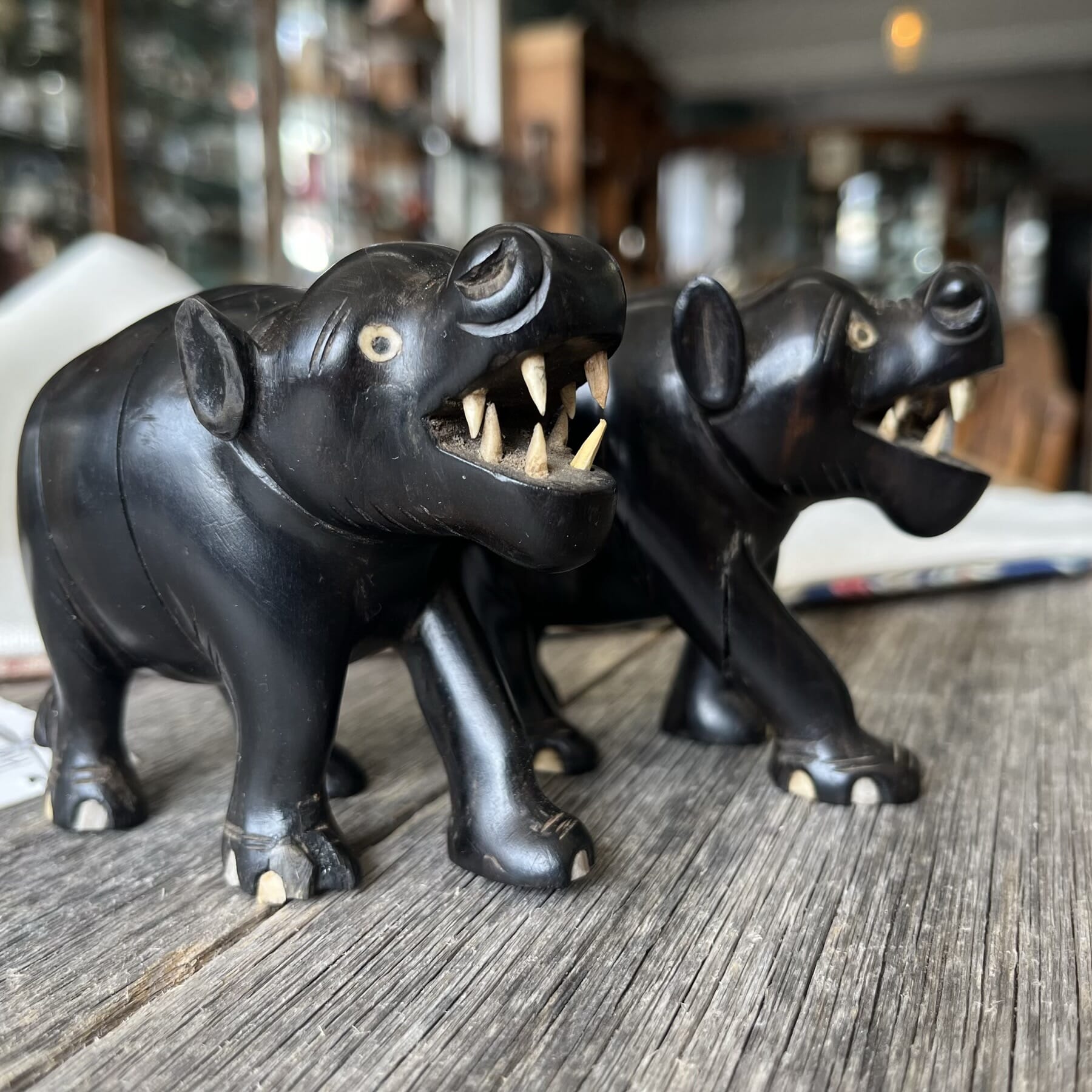 Pair of carved stylised ebony hippos, C. 1900