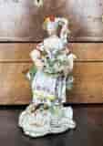 Derby figure of a girl with a basket of flowers on a rococo base, C. 1780