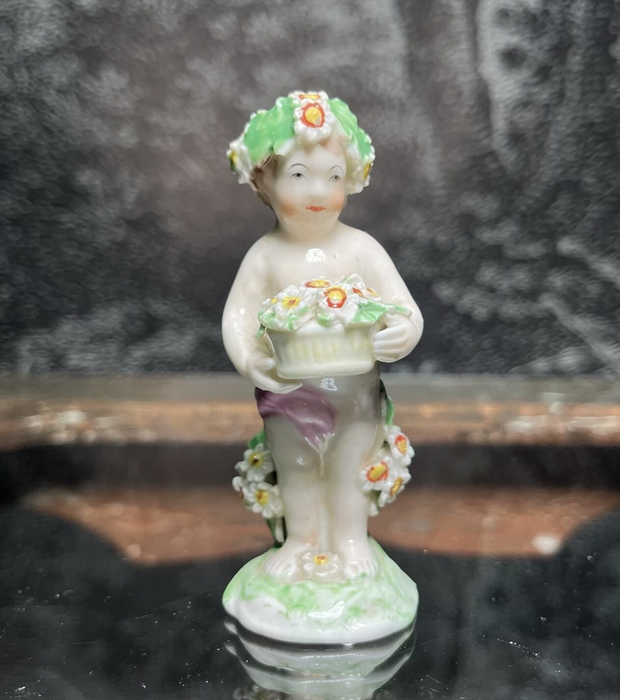 Derby figure of a boy, standing holding a basket of flowers circa 1785