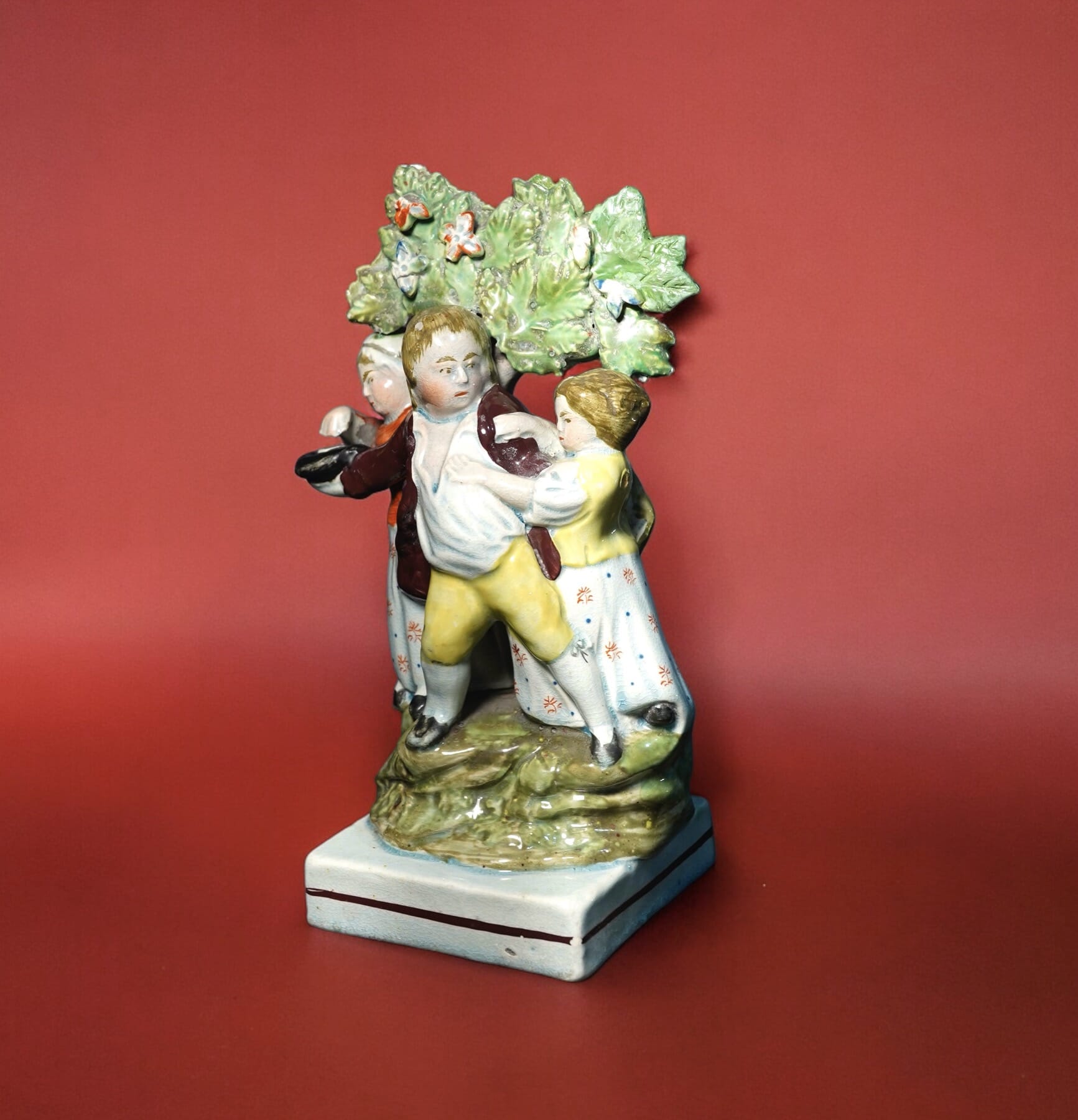Early Staffordshire'Contest' group, 3 children before bocage, attr. Dudson c. 1810