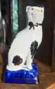 Staffordshire pottery cat with copper lustre on a blue cushion C.1900